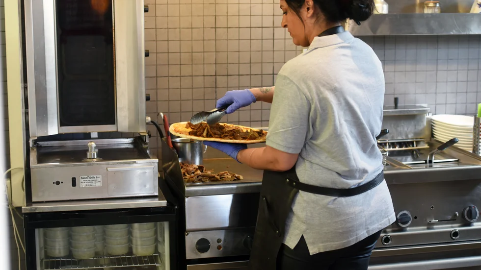 Yasmin Bamshad har precis öppnat sin första pizzeria. På bilden är det storsäljaren kebabpizza som fixas till.