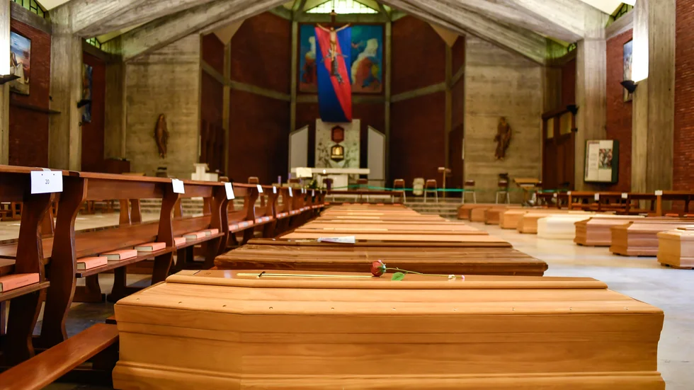 Kistor som ska vidare till ett krematorium ligger på golvet i San Giuseppe-kyrkan Seriate i provinsen Bergamo i Italien.