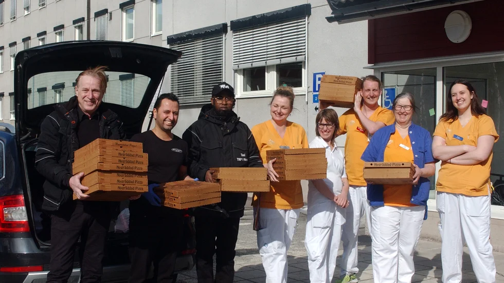 Ulf Dalberg, Mohamud Ali Nuur och Khabat Hamid levererar pizza till hungrig personal på hälsocentralen. Från vänster Nina Lundgren, Linda Beckert, Per Stenlund, Anna-Maria Jacobsson och Emma Lundgren.