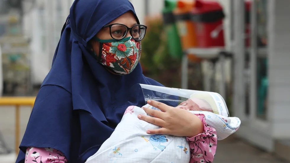 En kvinna med sitt barn på ett sjukhus i Indonesiens huvudstad Jakarta under coronapandemin. Arkivbild.