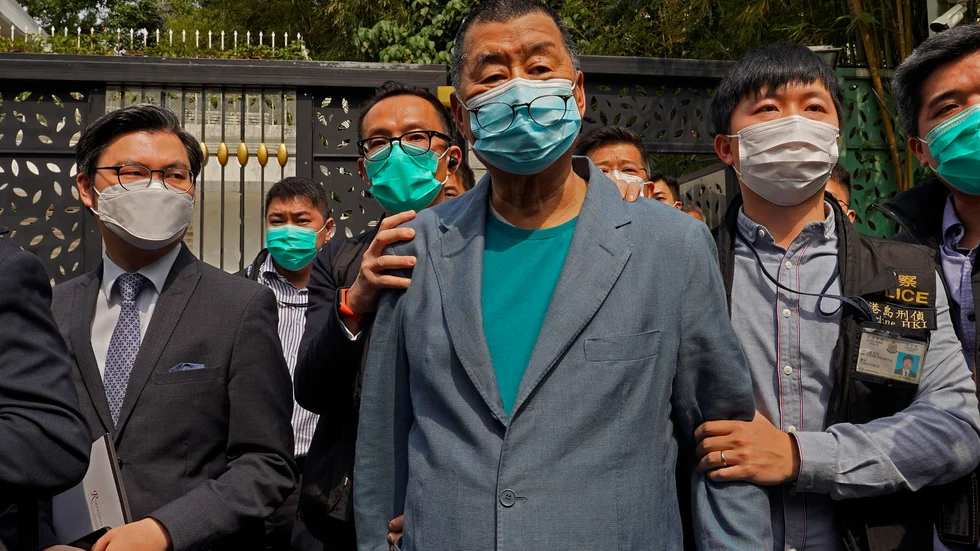 Mediemogulen och demokratiaktivisten Jimmy Lai, som grundat den lokala tidningen Apple Daily, leds bort av polis efter att ha gripits i sitt hem i Hongkong på lördagen.