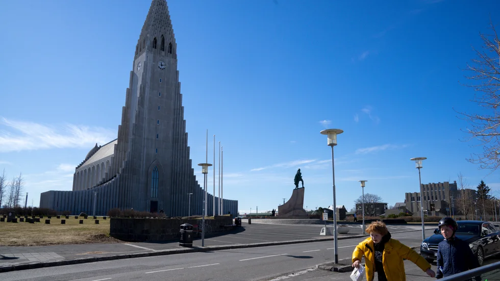 Två pojkar passerar ett tomt torg framför Hallgrímskirkja i Reykjavik i slutet av april, då landet meddelade lättnader i coronarestriktionerna.