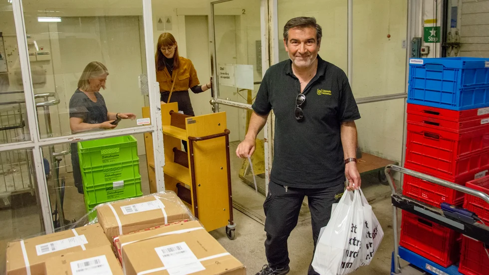Theo Karpashlis har hämtat en bokkasse hos Kristina Starlander och Sara Bengtsson på Uppsala stadsbibliotek.