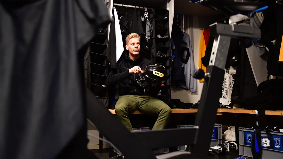 Kalle Mårtensson skruvar på det galler han måste ha på hjälmen efter att ha fått en skruv fastsatt i käken efter en gammal bandyskada sedan tiden i Ljusdal.