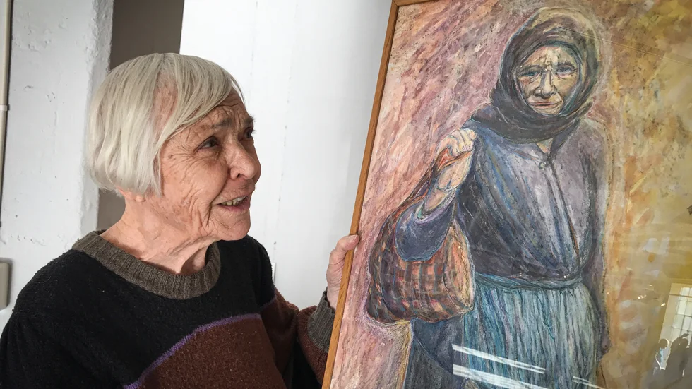 Aina Larsson med ett av sina många tavlor med motiv inspirerade av Grekland. I dag inleds hennes utställning på bruket i Hälleforsnäs.