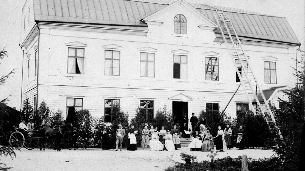 Stadshuset/Stadskällaren vid Storgatan i kvarteret Häggen i Piteå. På innergården står personalen uppradad. Fotot är från 1890-talet.