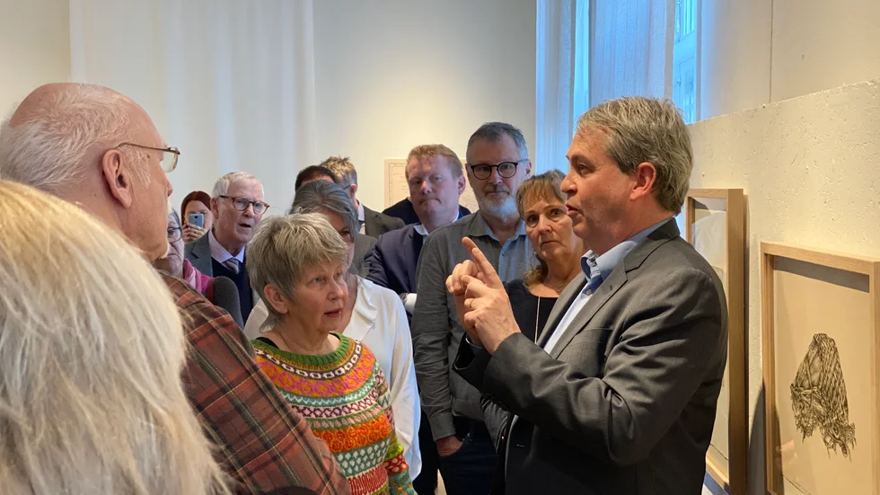 Pär Ahlberger, ambassadör i Australien och Nya Zeeland 2014–2019, visar runt besökarna på utställningen.