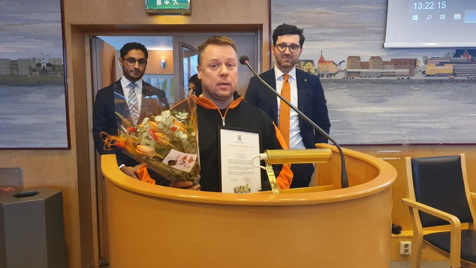 Conny Broström prisades vid kommunfullmäktige i Luleå. I bakgrunden Daniel Smirat (S), vice ordförande i kommunfullmäktige, och Nihad Zara (M), ordförande i fullmäktige.
