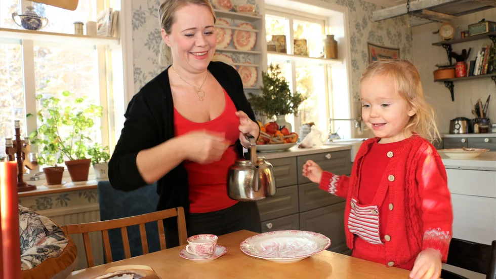 Hannah Bergstedt och dottern Tyra fikar hemma i det gamla, välbevarade köket.