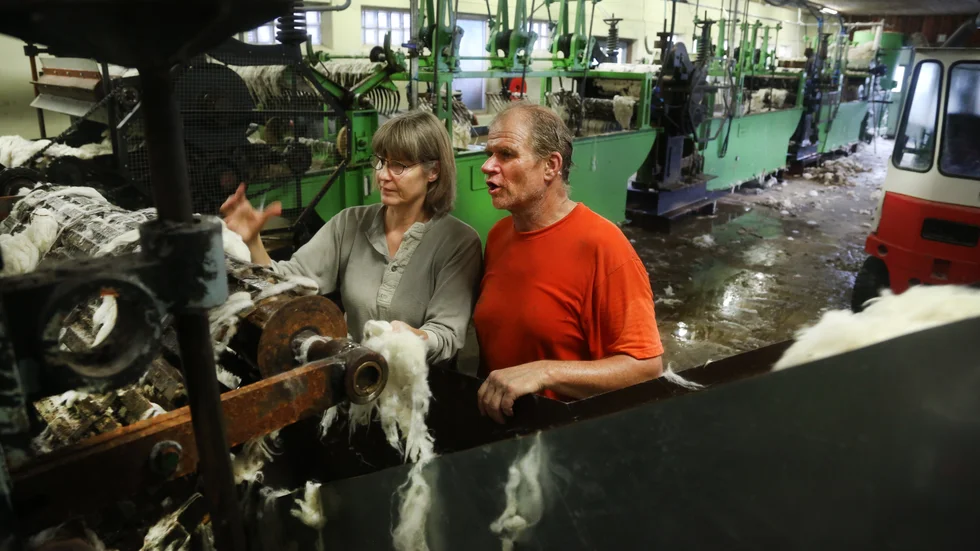 Jenny Andersson och Hans Bulthuis vid valsarna som pressar ut vattnet ur ullen efter avslutad tvätt. 