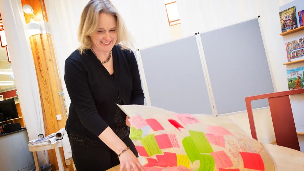 Linda Axelsson, Planchef på Trosakommun plockar ner översiktsplanen från biblioteket i Trosa.