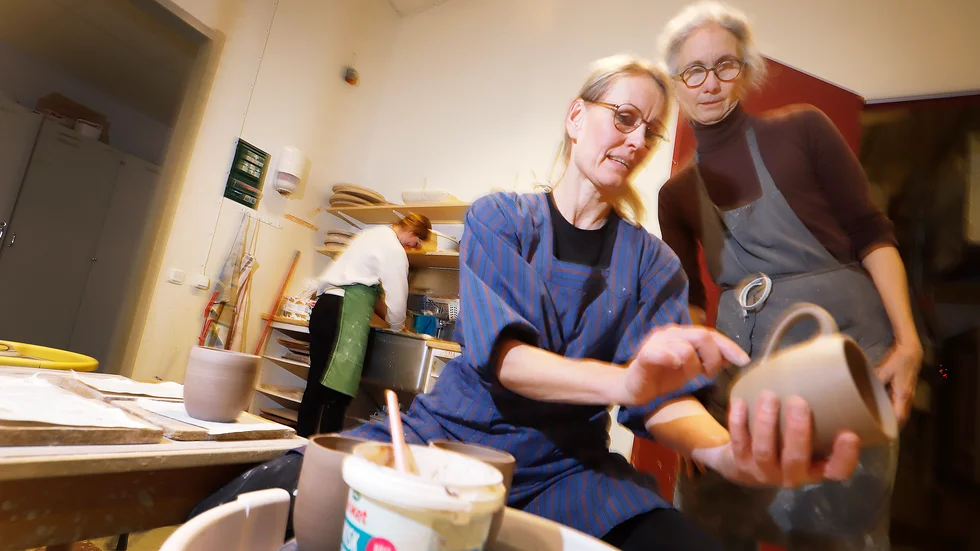 "När man sätter sig vid drejskivan kopplar man bort allt annat – det är magi", säger kursdeltagaren Christina Andrae. Kursledaren Maria Skärlund konsulteras innan temuggarna får sina öron på plats.
