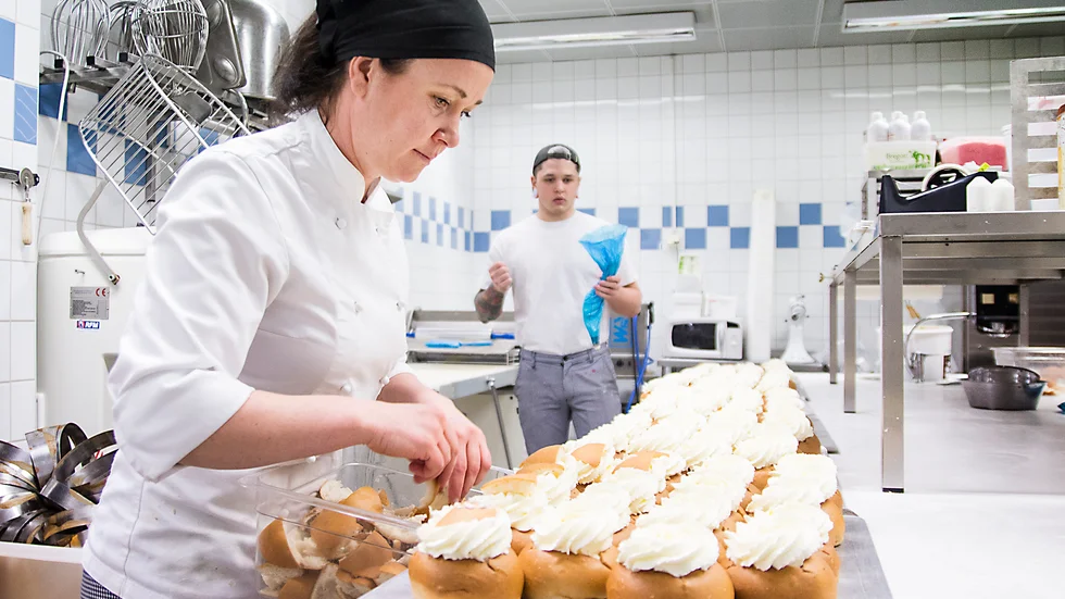Johanna Stenberg och Axel Olsson gör semlor på löpande band.