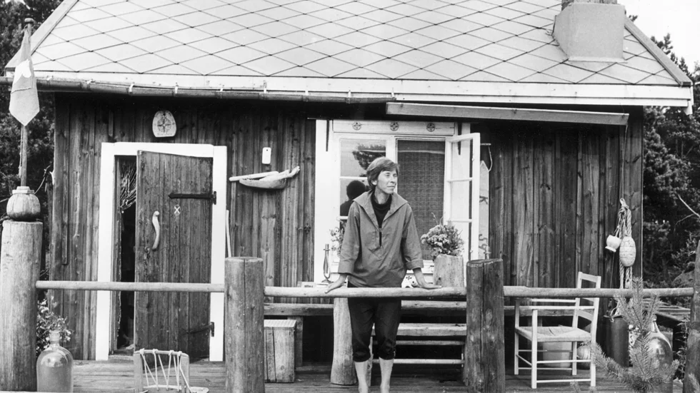 Tove Jansson hade flera hus på ön Bredskär i Finska Viken. Här står hon 1961 på verandan till ett av sina Muminhus, "Vindrosens hus" som hon själv byggde, en tillgång krönikören Elin Ruuth gärna haft.