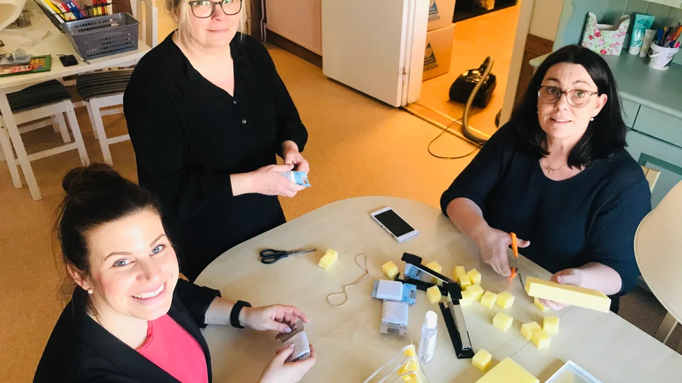 Enhetschef Gabriella Rogic och arbetshandledarna Sinikka Patay och Rosi Runnkvist tillverkar visir i dagligverksamhetens tomma lokal på Klostergatan. "Att åka runt och leta material tar tid."