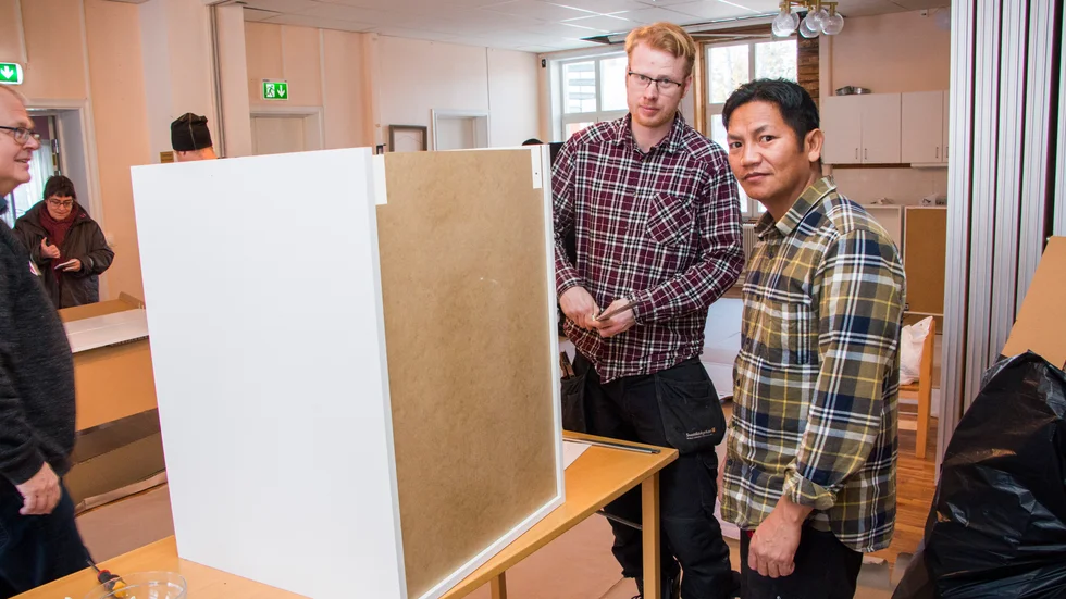 Församlingens vaktmästare Andreas Belander och Tluang Peng Cin Khupla monterade skåpstommar för glatta livet.