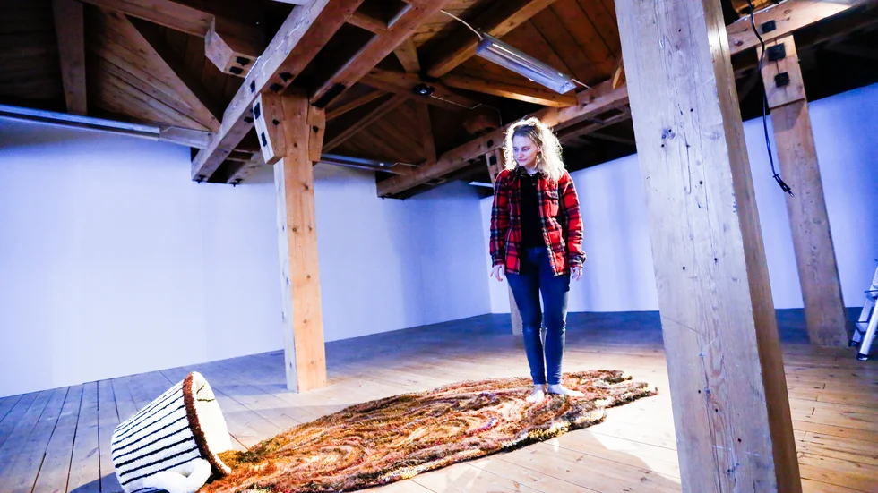 Maja Michaelsdotter Eriksson tillsammans med sitt verk "Till the End of the World" - en skulptur där hon använt sig av tuft, en halvindustriell teknik för att tillverka mattor.