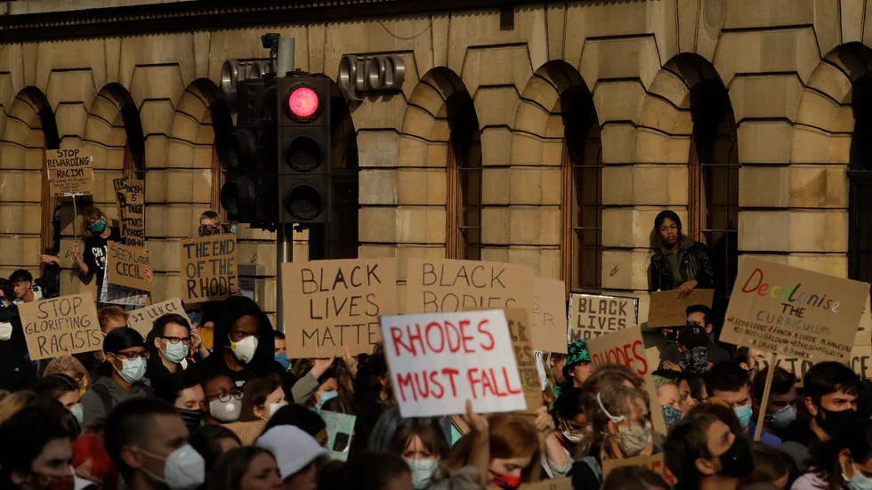 Tusentals människor samlades under tisdagskvällen utanför ett college i den brittiska staden Oxford i protest mot en staty av den brittiske kolonisatören och affärsmannen Cecil Rhodes.