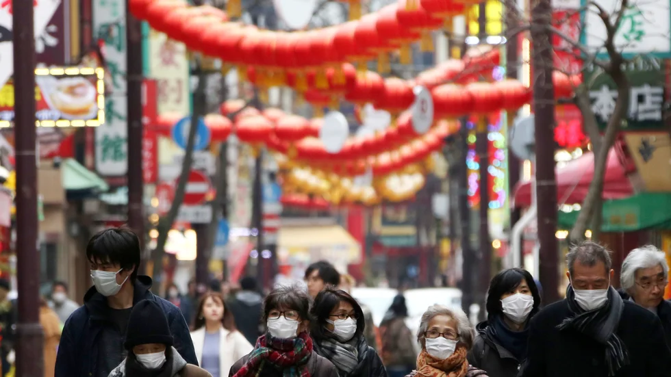 Människor i ansiktsmundering i Chinatown-området i Yokohama, Japan.