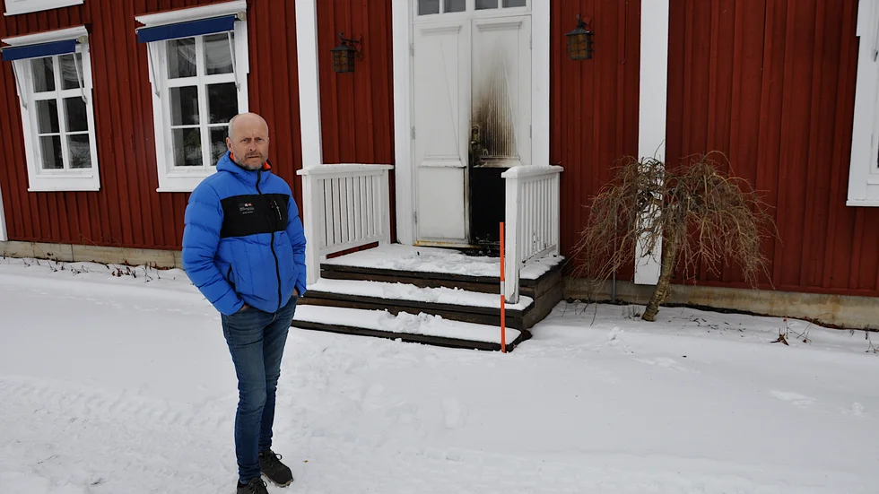 Kennet Silverplats vid den brända dörren på Norrigårdens framsida.