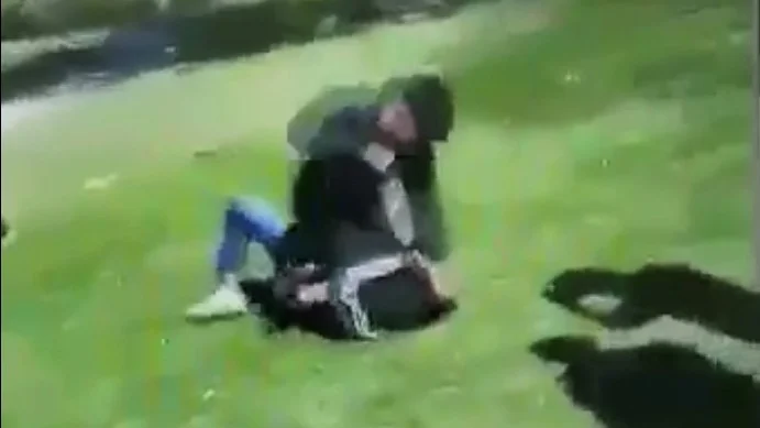 En kille blir misshandlad under hejarop och kampsånger i Folkparken.
