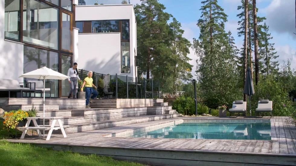 Åsa Sagebro (i gul tröja) kollar in en av de tävlandes hus - eller är hon hemma hos sig själv? Foto: SVT