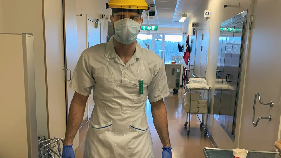 Marcus Dinler med sin arbetskostym som undersköterska på ortoped- och pandemiavdelningen på Vrinnevisjukhuset.