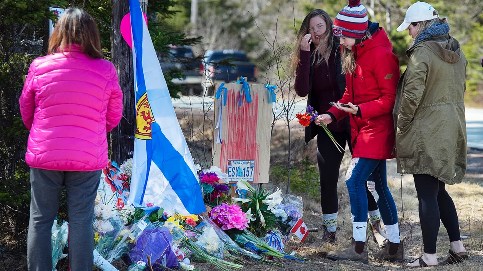 Människor hedrar offren vid en spontan minnesplats i Portapique i Nova Scotia.