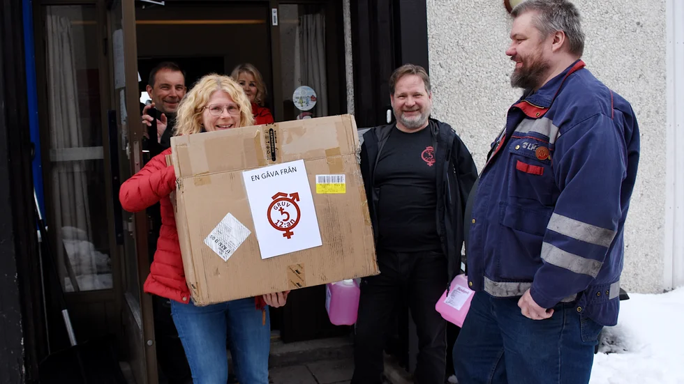 Åsa Pesonen, Kommunal, tar emot 600 andningsmasker från Gruvtolvans Bengt Holmlund och Lars-Göran Niemelä. I bakgrunden syns Per Eriksson och Gunilla Eliasson. 