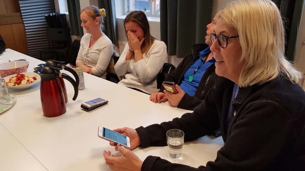 På arbetsplatsträff kommer mobilerna fram. Digital teknik används både för hemtjänstbesök, men också för att ta tempen på stämningen i arbetsgruppen. Yvonne Rundberg är närmast i bild. 