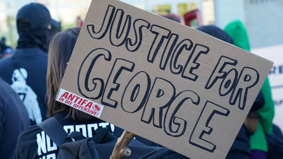 Ett plakat med texten "rättvisa för George" med ett Antifa-klistermärke i hörnet. Arkivbild.