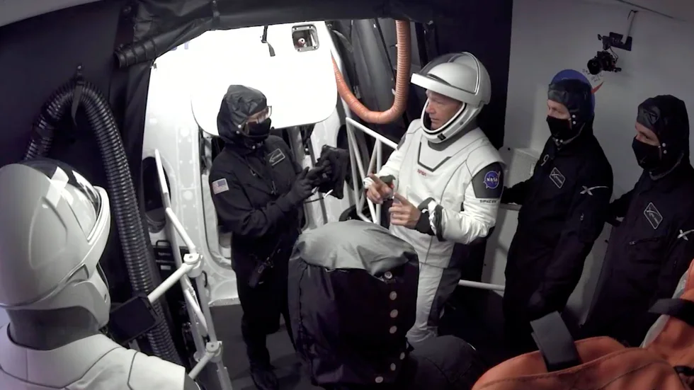 Astronauterna Doug Hurley och Bob Behnken lämnar kapseln Crew Dragon efter onsdagens avbrutna försök att skjuta upp raketen.
