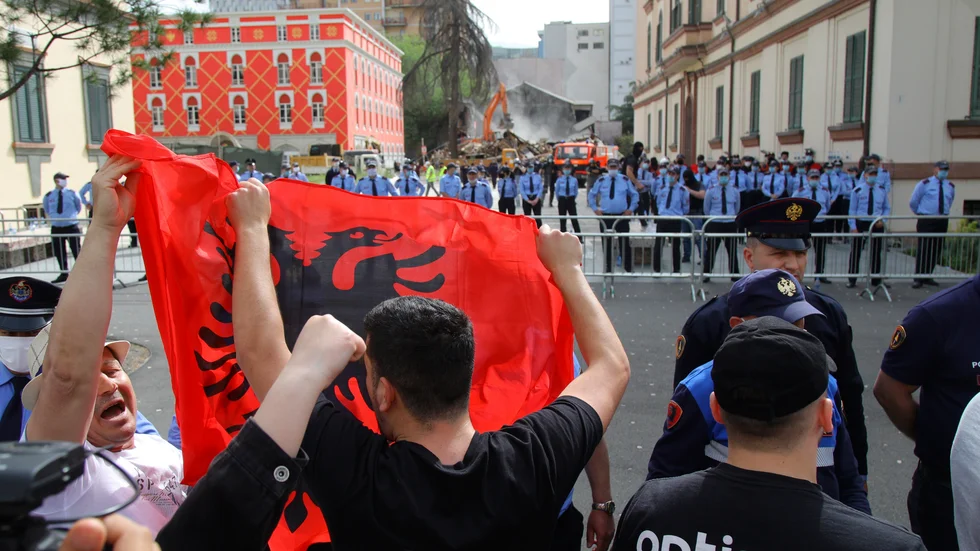 Demonstranter med den albanska flaggan protesterar mot rivningen av landets nationalteater på söndagen.