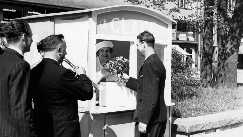 Här en bild från 1943 då en samtida berömd musiker i Norge överraskar sin mamma på arbetet i en glasskiosk med en blomma på Mors dag. 