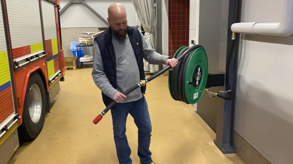 Stationsbefälet Johan Jansson visar hur den brandpost som finns på stationen ser ut. Den uppfyller inte de behov som finns för att fylla på en brandbil snabbt.