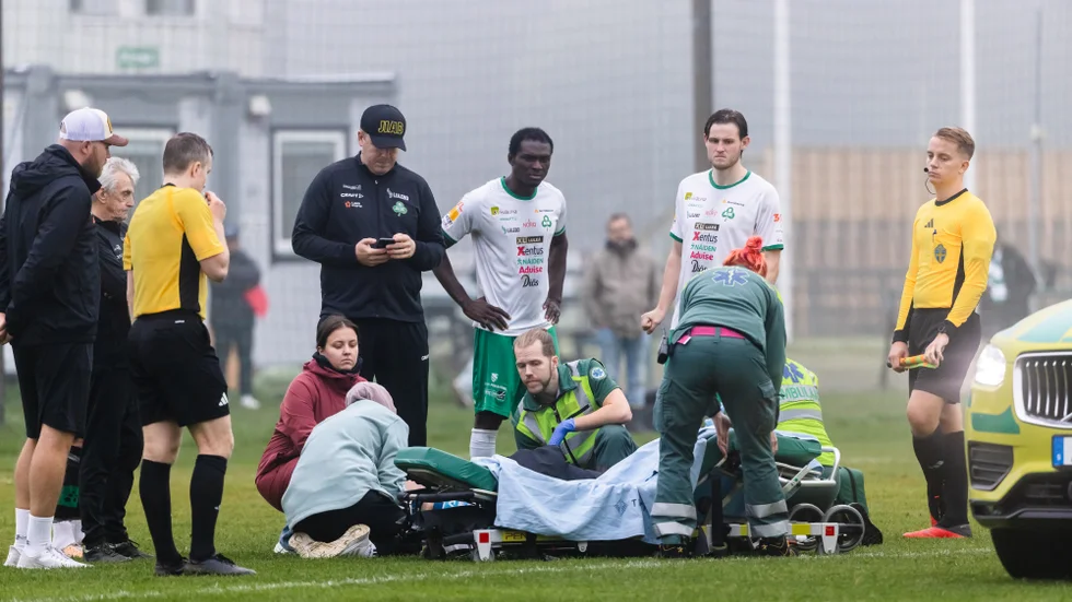 Åke Tornberg tas om hand av ambulanspersonalen. Mittbacken fick en smäll tidigare i matchen, men föll sedan ihop i ett spelavbrott.
