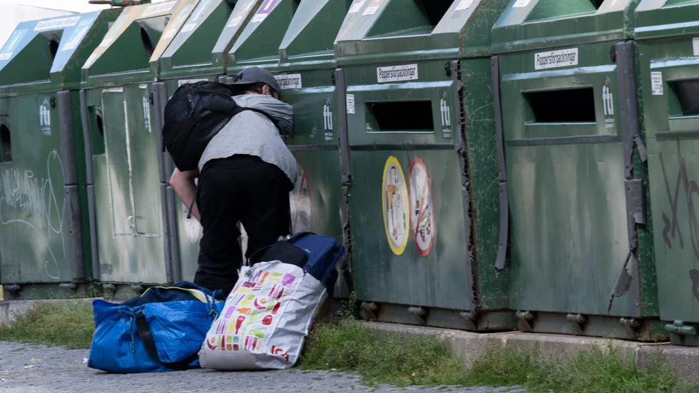 En man letar efter fynd i container. Många av de nyfattiga i Sverige går under myndigheternas radar.


