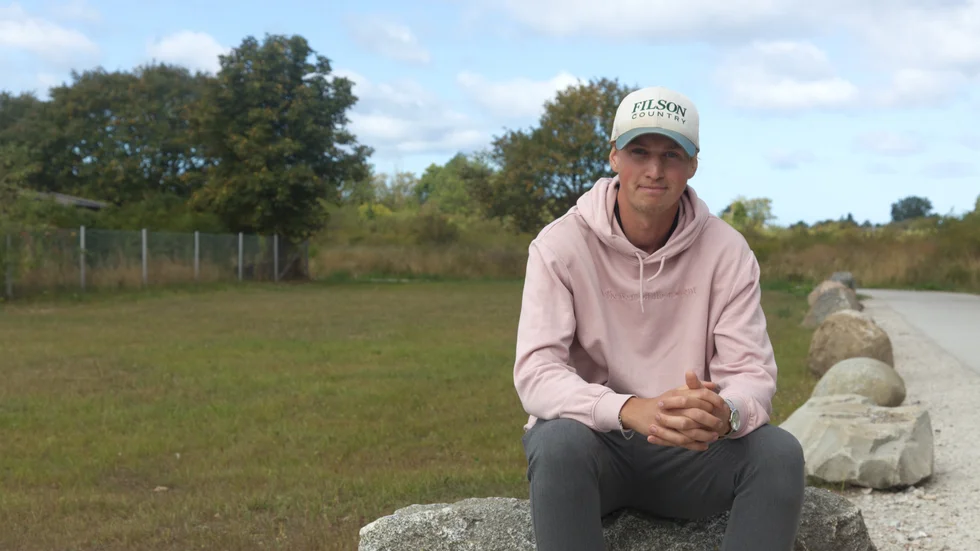Jonathan Westerlund på stenarna som hindrar boende att parkera. Där det tidigare var en grusplan växer nu en gräsmatta. 