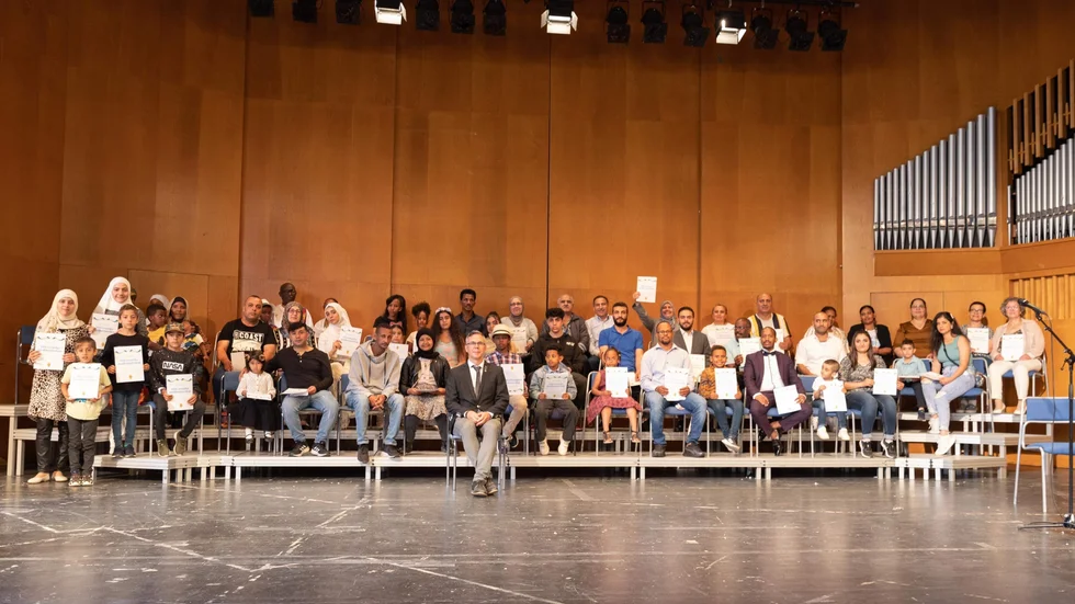 De nya medborgarna hälsades välkomna av Katrineholms kommun under en ceremoni i Tallåsskolans aula. Längst fram sitter Johan Söderberg (S), kommunstyrelsens ordförande. 