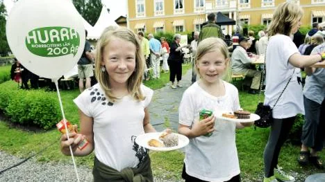 Sofia Johansson, 10, och kompisen Tindra Sandelid, 8, njöt av fikat ute vid serveringen i Residensparken. Norrbotten fyller 200 år. FOTO: Bengt-Åke Persson