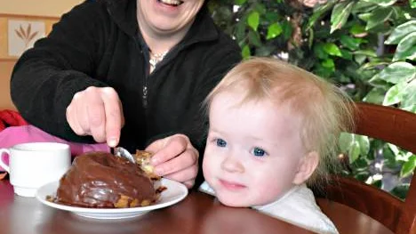 Annika Olausson blir glad över beskedet om gratis barnomsorg. Dottern Matilda Engelmark firar med ett chokladwienerbröd.                                                                                                                                                                                                                    FOTO: Maria Ödalen