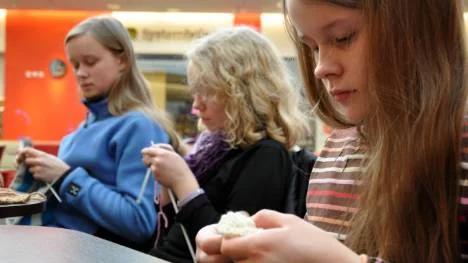 Tuva Bryggare räknar maskorna i sin halsduk, som hon stickar i en speciell teknik. Intill henne Anna Rönnkvist och längst bort Elin Bryggare. FOTO: Lotta Nilsson