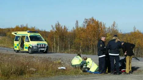 Ambulanspersonalen tar hand om den skadade mc-föraren, som körde av vägen i en kurva och skadade huvudet.FOTO: Alexander Linder