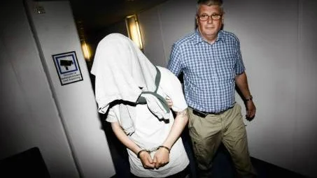 Den 24-årige mannen förs in i tingssalen av kriminalinspektören Sture Pettersson. 24-åringe häktade som skäligen misstänkt för grovt rån. Foto: SIMON ELISASSON