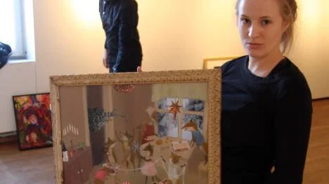 Anna Häggström på väg att hänga upp sin olja/collage som bär namnet I rävlyan. Hon är konstelev på Svenskfinska folkhögsolan i Haparanda. I bakgrunden Rikard Ölund, Älvsbyn, konstelev i Sunderbyn.