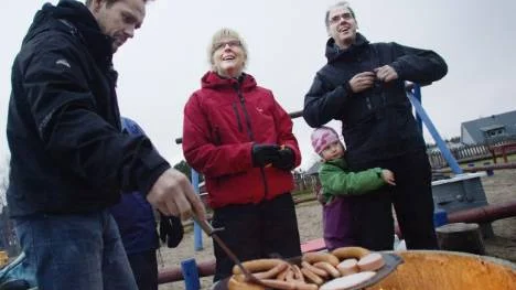 Föräldrarna Per-Erik Andersson, Carola Vånsjö och Johannes Arnesen (omkramad av dottern Randi) grillar korv på muurikka över öppen eld vid invigningen av ur och skur-förskolan Skatan.FOTO: Maria Ekman