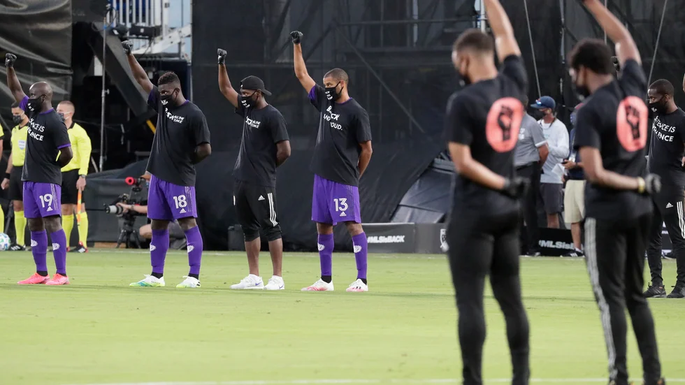 Orlandos spelare, till vänster, höjde sina nävar i protest mot rasistiskt våld före matchen.
