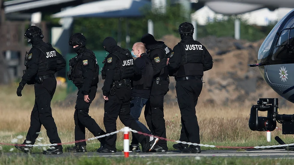 Den åtalade för attacken vid en synagoga i Halle förs till rättssalen i tyska Magdeburg under en av de första rättegångsdagarna, i juli.
