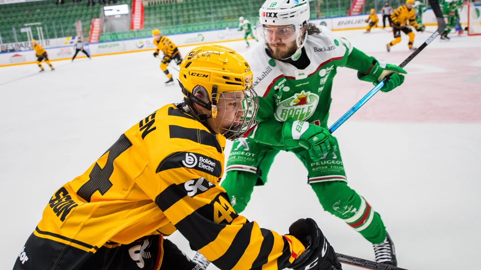 Elias Salomonsson, som här är hundradelar från att bli tacklad av Rögles Dennis Everberg, blev förste spelare född 2004 att spela i SHL under torsdagskvällen.