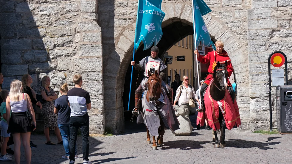 Torneamentums covidriddare ska påminna om att hålla avstånd under högskommarveckorna på Gotland. Här syns Thomas Lindgren på hästen Soprano och Anders Månsson på hästen Sara.